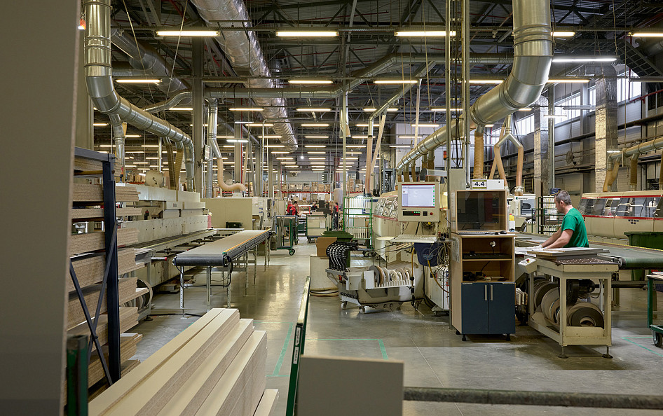 Будущие фасады из экоплиты сразу после распила попадают на линию кромкования. Кромка (лента) присоединяется к торцу фасада по технологии «Вечное соединение» (Pur Cont). Кромка и плита соединяются намертво и не отслаиваются со временем.